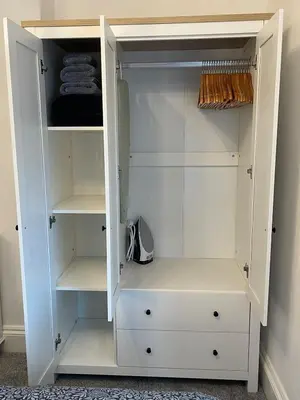 a white closet with white drawers and shelves at Cosy Cottage, Mevagissey in Mevagissey