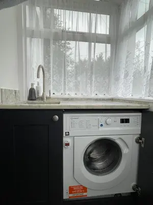 a washing machine in a kitchen with a window at Cosy Cottage, Mevagissey in Mevagissey
