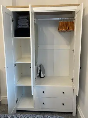 a white walk in closet with white shelves at Cosy Cottage, Mevagissey in Mevagissey