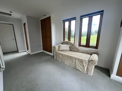 a empty living room with a couch and windows at Trelean Lodge in Leedstown