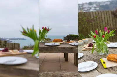a table with plates of food and flowers on it at Heatherleigh in Carbis Bay