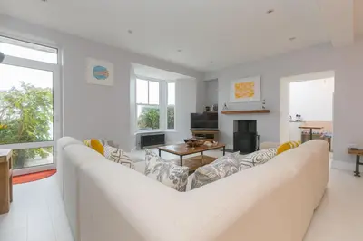 a living room with a couch and a table at Heatherleigh in Carbis Bay