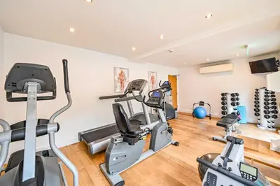 a gym with several treadmills and cardio machines at House 17 in Looe