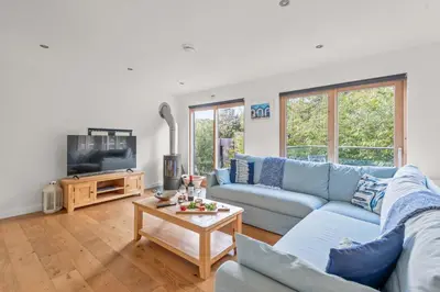 a living room with a blue couch and a tv at House 17 in Looe