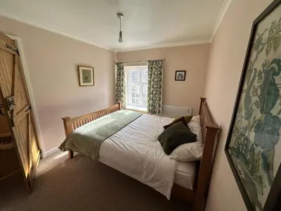 a small bedroom with a bed and a window at Levalsa House in Pentewan