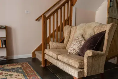 a chair with two pillows sitting next to a staircase at Levalsa House in Pentewan