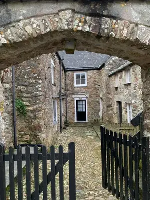 an old stone building with a fence in front of it at Levalsa House in Pentewan