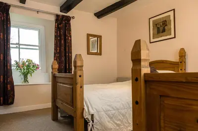 a bedroom with a wooden bed and a window at Levalsa House in Pentewan