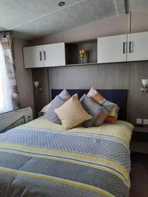 a bed with pillows on it in a room at Sunset retreat lodge with large wrap around decking in Newquay