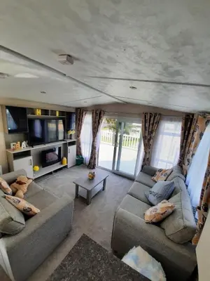 a living room with two couches and a tv at Sunset retreat lodge with large wrap around decking in Newquay