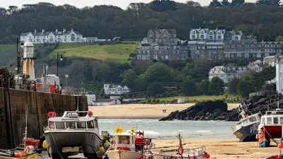 a group of boats docked on the shore of a beach at Bijou in St Ives