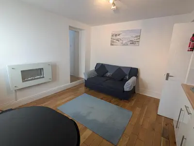 a living room with a couch and a tv at Bijou in St Ives