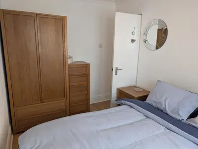 a bedroom with a bed and a wooden closet at Bijou in St Ives