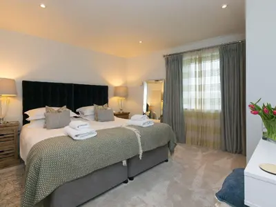 a bedroom with a large bed and a mirror at Wingspan in St Ives