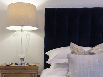 a lamp on a night stand next to a bed at Wingspan in St Ives