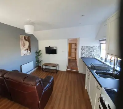 a kitchen and living room with a couch and a table at SeaView-PetsOK-Patio-1BR in Mevagissey