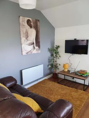 a living room with a couch and a tv at SeaView-PetsOK-Patio-1BR in Mevagissey