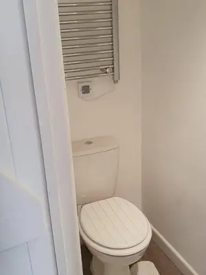 a bathroom with a white toilet and a window at SeaView-PetsOK-Patio-1BR in Mevagissey