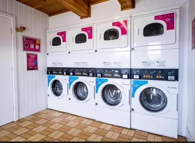 four washers and dryers are in a laundry room at 151 Newquay Bay Resort in Porth