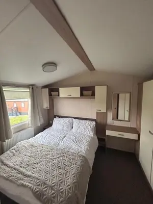 a bedroom with a white bed and a window at 151 Newquay Bay Resort in Porth