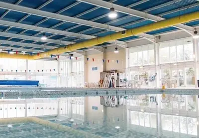 an empty swimming pool with its reflection in the water at 151 Newquay Bay Resort in Porth