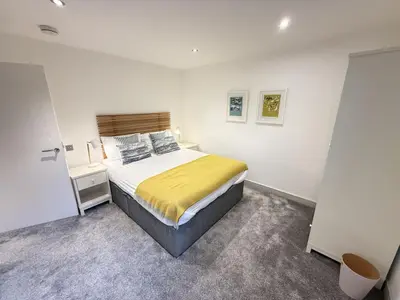 a bedroom with a bed and a desk in it at Fishers View, Castle Approach, Tregenna Castle in St Ives