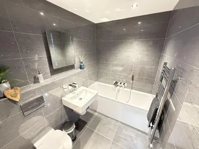 a bathroom with a sink and a tub and a toilet at Fishers View, Castle Approach, Tregenna Castle in St Ives
