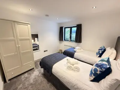 a room with two beds and a window at Fishers View, Castle Approach, Tregenna Castle in St Ives