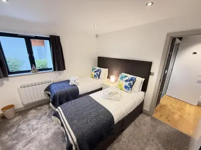 a bedroom with two beds and a window at Fishers View, Castle Approach, Tregenna Castle in St Ives