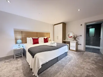 a large bedroom with a large bed and a window at Fishers View, Castle Approach, Tregenna Castle in St Ives
