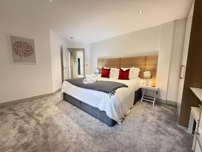 a bedroom with a large bed with red pillows at Fishers View, Castle Approach, Tregenna Castle in St Ives
