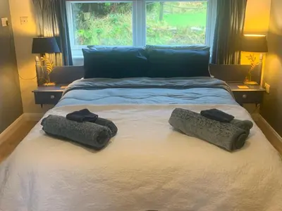 a bedroom with a bed with two towels on it at Stable End in Liskeard