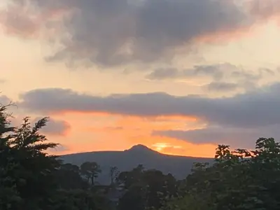 a sunset with a mountain in the background at Stable End in Liskeard