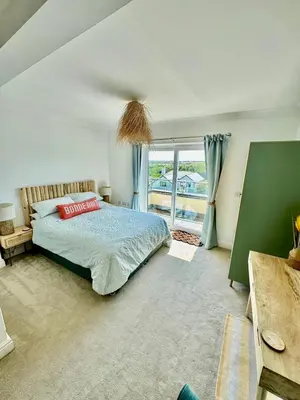 a bedroom with a bed and a large window at Penthouse Sea View Newquay Fistral Beach 3 Min Walk in Crantock