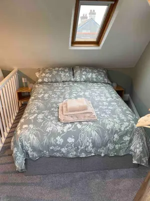 a bed with a blanket and a towel on it at Sea Glimpses Studio Port Isaac in Port Isaac