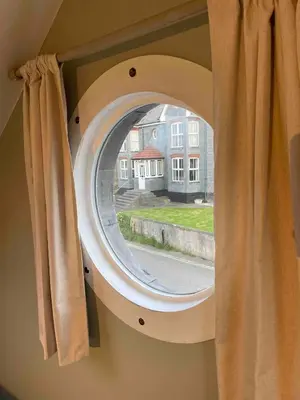 anorthole window in a house with around window at Sea Glimpses Studio Port Isaac in Port Isaac