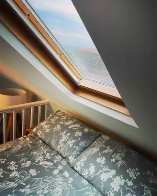 a window in a bedroom with a bed and a crib at Sea Glimpses Studio Port Isaac in Port Isaac