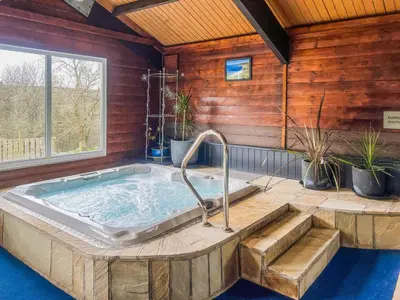 a jacuzzi tub in a room with a window at Culver Cottage - Uk48987 in Looe