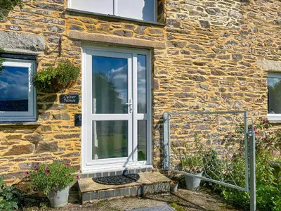 a stone house with a white door at Culver Cottage - Uk48987 in Looe
