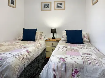two beds sitting next to each other in a bedroom at Culver Cottage - Uk48987 in Looe