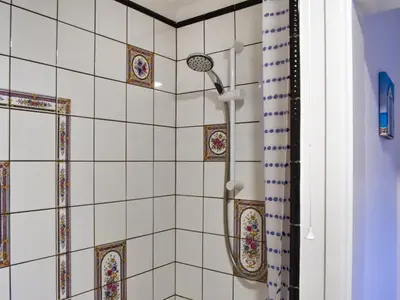 a bathroom with a shower with tiles on the wall at Culver Cottage - Uk48987 in Looe