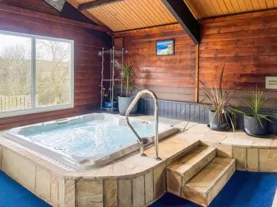 a jacuzzi tub in a room with a window at Linney Cottage - Uk48986 in Looe