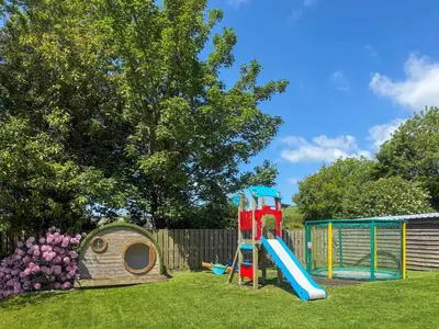 a playground with a slide and a play house at Linney Cottage - Uk48986 in Looe