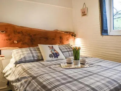 a bed with a tray with flowers on it at Linney Cottage - Uk48986 in Looe