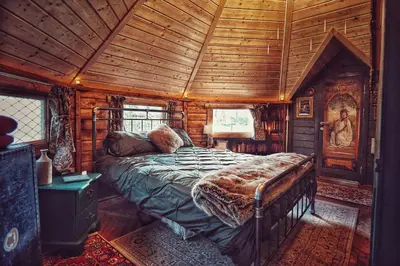 a bedroom with a bed in a wooden cabin at The Wizards Cauldron -Harry Potter Themed in Lewannick