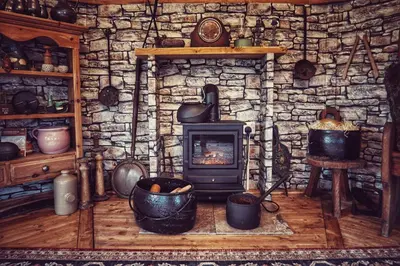 a stone fireplace in a room with a stove at The Wizards Cauldron -Harry Potter Themed in Lewannick