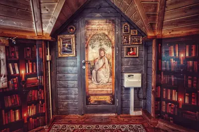 a door in a library with a painting on it at The Wizards Cauldron -Harry Potter Themed in Lewannick