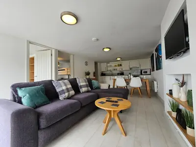 a living room with a purple couch and a table at Luxury Sea View Chalet At Millendreath in Looe