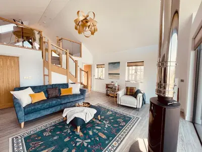 a living room with a blue couch and a rug at The Lake House , luxury rural retreat in Ladock