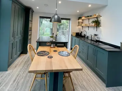 a kitchen with a wooden table and some chairs at The Lake House , luxury rural retreat in Ladock